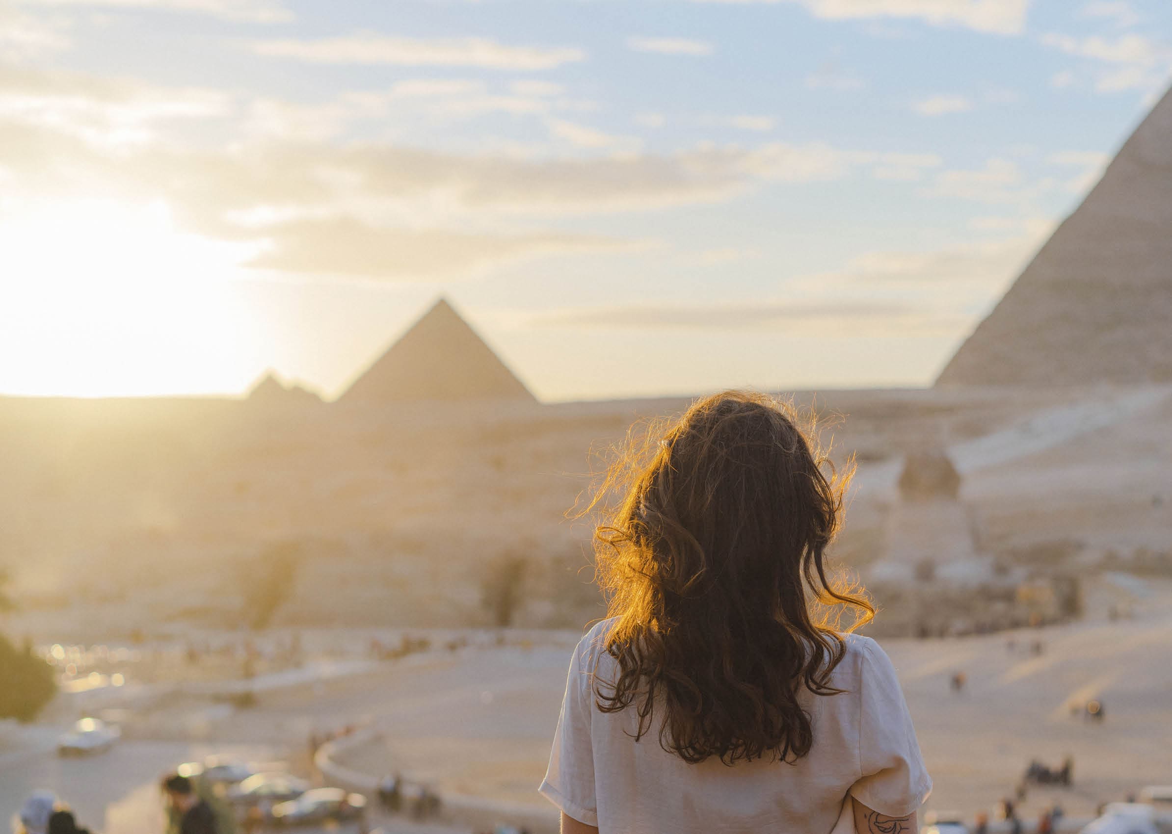 Young Caucasian woman standing on the terrace on the  background of Giza pyramids