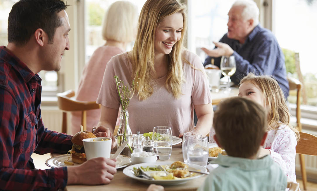 Family Enjoying Meal In Restaurant Together