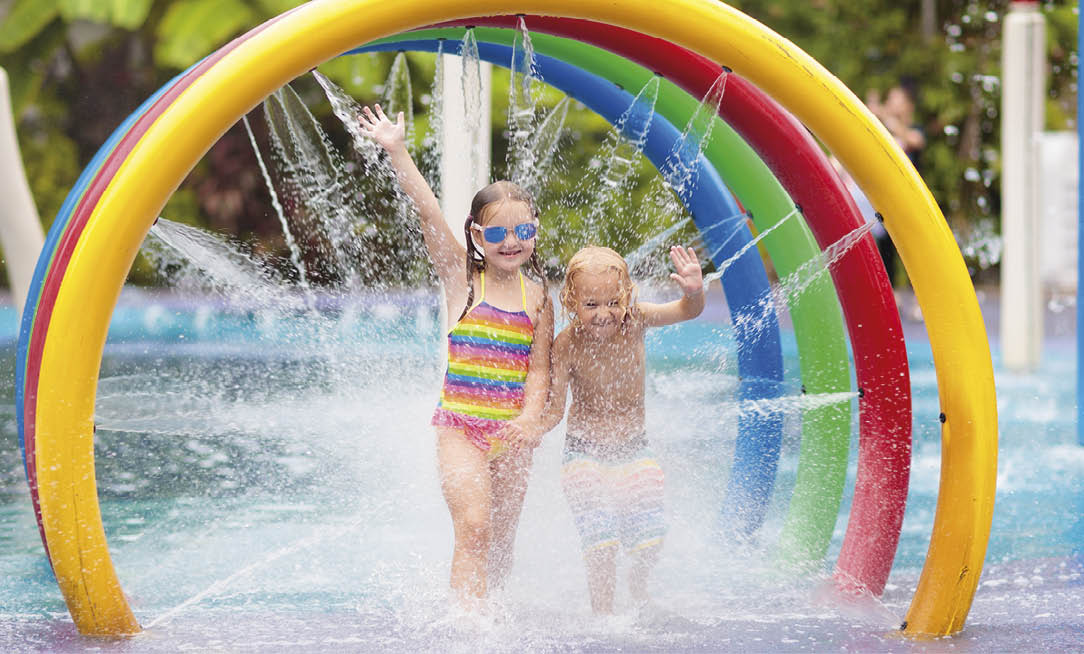 Kids play in aqua park. Children at water playground of tropical amusement park. Little girl and boy at swimming pool. Child playing at water slide on summer vacation in Asia. Swim wear for young kid.