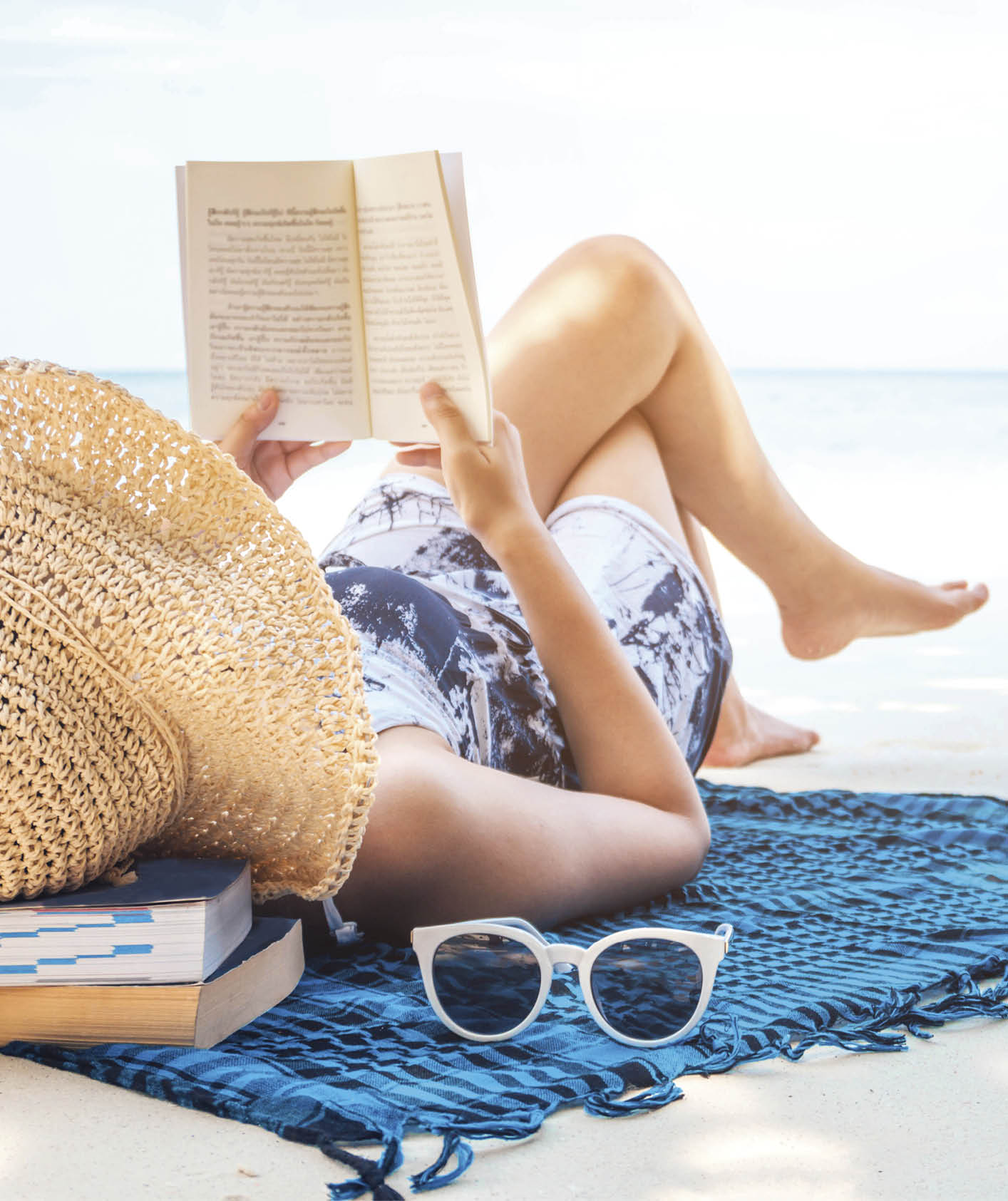 Woman reading a book on the beach in free time summer holiday