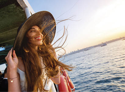 Happy woman enjoying the sea from ferry boat crossing Bosphorus in Istanbul