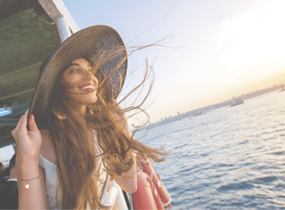 Happy woman enjoying the sea from ferry boat crossing Bosphorus in Istanbul