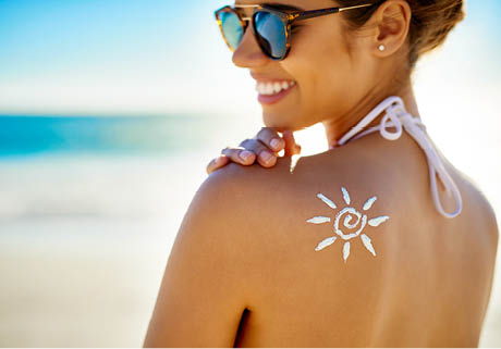 Cropped shot of a young woman posing with suntan lotion on her shoulder