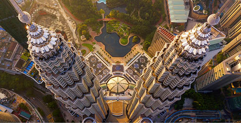 Top of Petronas Twin Towers. Aerial view of Kuala Lumpur Downtown, Malaysia. Financial district and business centers in smart urban city in Asia. Skyscraper and high-rise buildings at sunset.