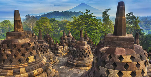 Candi Borobudur in the background of rainforest, morning mist and Sumbing Mountain.