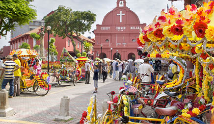 MELAKA, MALAYSIA - JAN 14 : Christ Church Melaka on Jan 14, 2012 in Melaka Malaysia. A popular historic tourist attraction in Melaka Malaysia with flower decorated tricycles for hire.