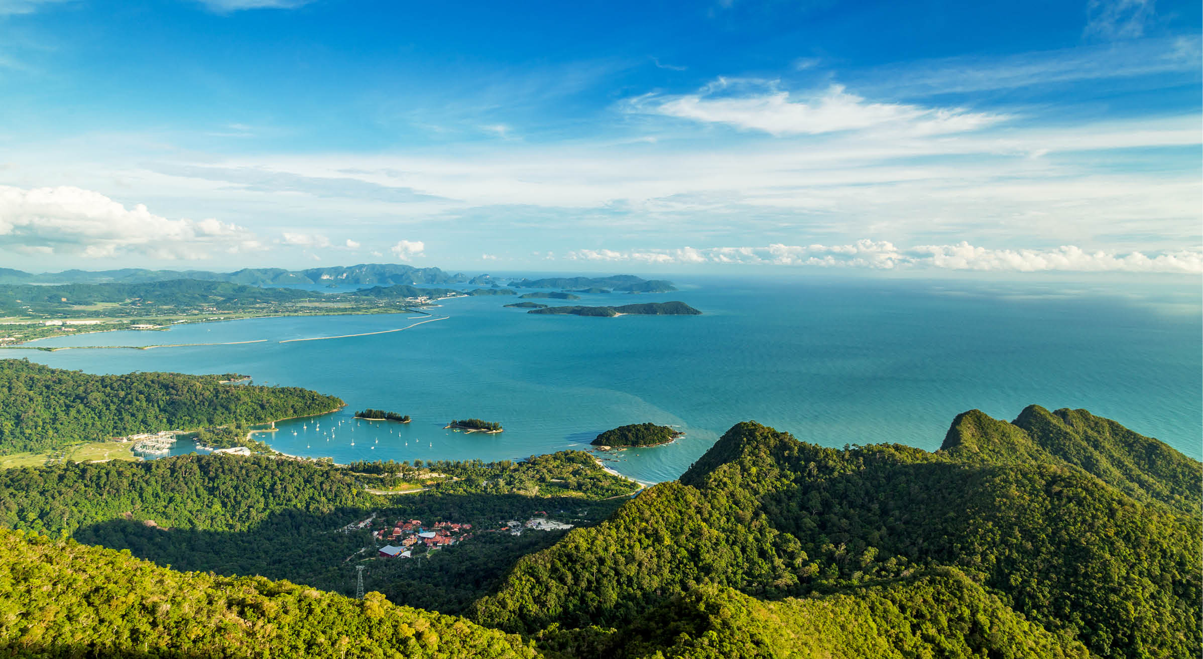 View of tropical island Langkawi in Malaysia, covered with tropical forests. Aerial view on the bay, marina and archipelago of smaller islands in Andaman sea.