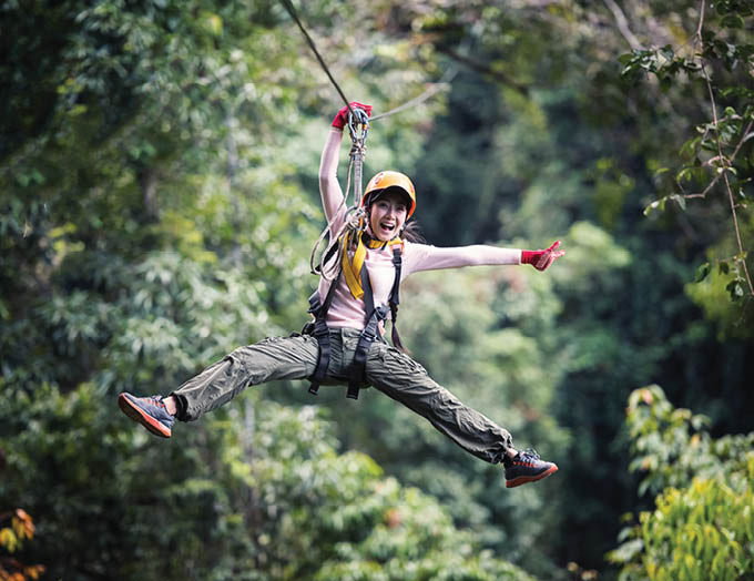 Freedom Woman Tourist Wearing Casual Clothing On Zip Line Or Canopy Experience In Laos Rainforest, Asia