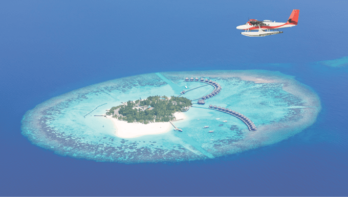 Sea plane flying above Maldives islands