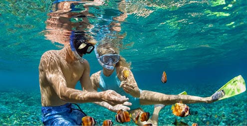 Happy family vacation  Young couple in snorkeling mask hold hand, dive underwater with fishes in coral reef sea pool  Travel lifestyle, watersport adventure, swim activity on summer beach holiday
