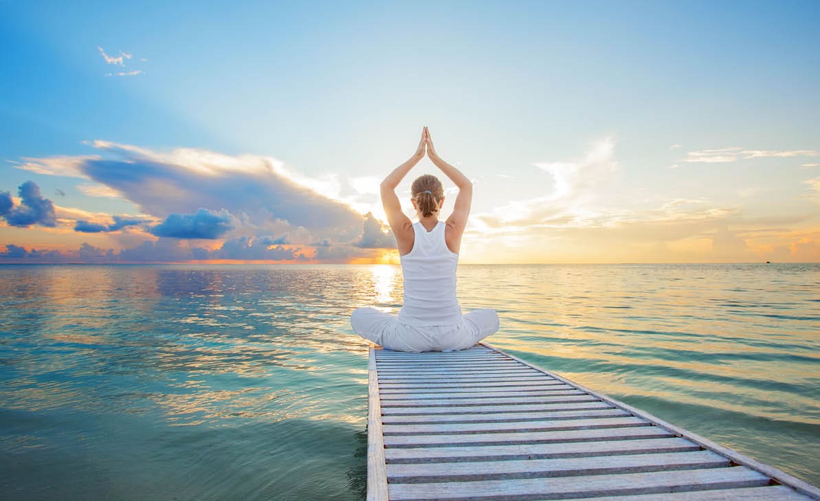 Caucasian woman practicing yoga at seashore