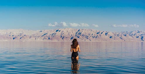 Girl is relaxing and swimming in the water of the Dead Sea in Israel