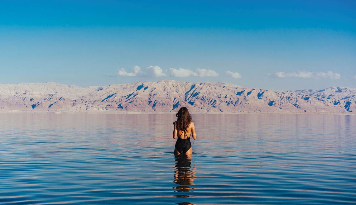 Girl is relaxing and swimming in the water of the Dead Sea in Israel