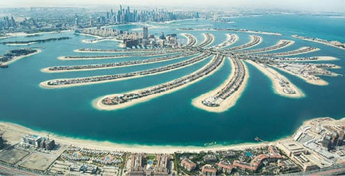 Aerial view of Palm Jumeirah man made island and Dubai Marina and JBR district on a sunny day. Dubai, UAE.
