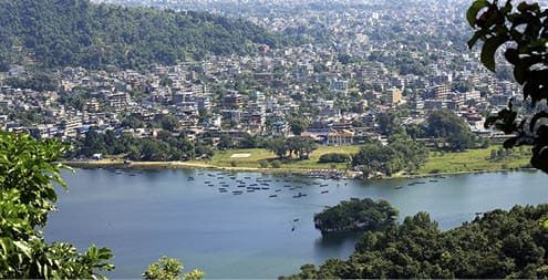 The 4.43 km2-784 ms.high Phewa tal-lake at foot of the Annapurnas range with Pokhara city seen from the way down Ananda Hill-Shanti Stupa-World Peace Pagoda. Kaski distr.-Gandaki zone-Nepal.