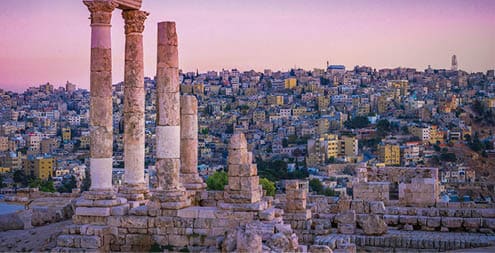 Amman, Jordan its Roman ruins in the middle of the ancient citadel park in the center of the city. Sunset on Skyline of Amman and old town of the city with nice view over historic capital of Jordan.