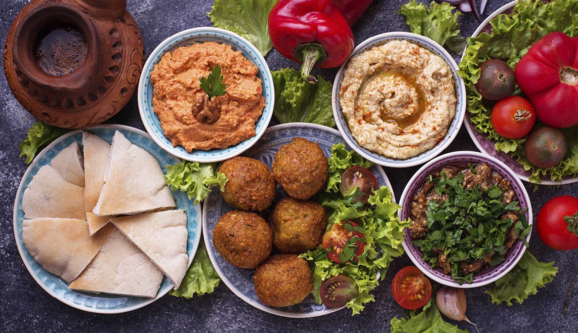 Selection of Middle eastern or Arabic dishes. Falafel, hummus, pita and muhammara. Top view