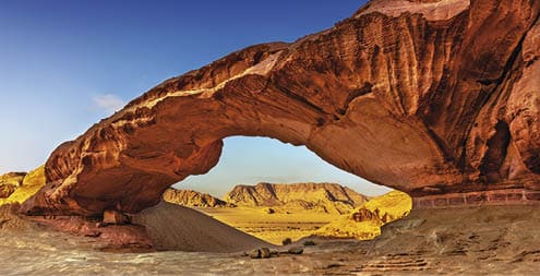 View through a rock arch in the desert of Wadi Rum, Jordan, Middle East