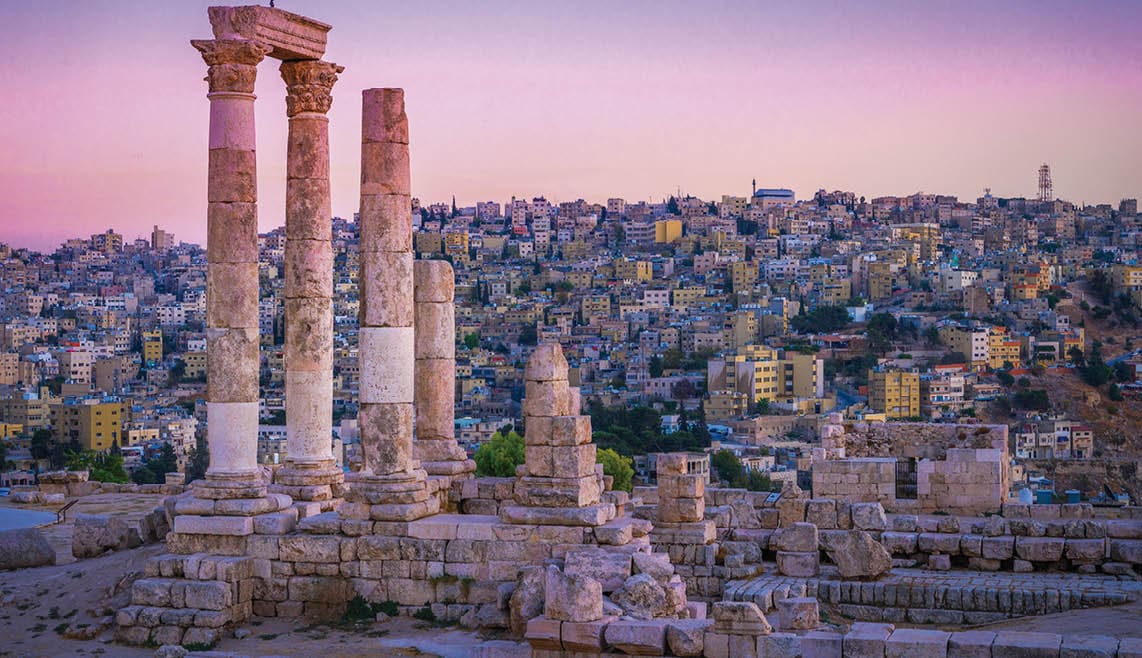 Amman, Jordan its Roman ruins in the middle of the ancient citadel park in the center of the city. Sunset on Skyline of Amman and old town of the city with nice view over historic capital of Jordan.